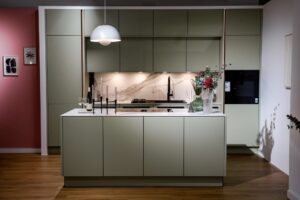 Kueche kaufen uechenbauer-salbeigruene-kueche-marmor-kochinsel-frontal-02